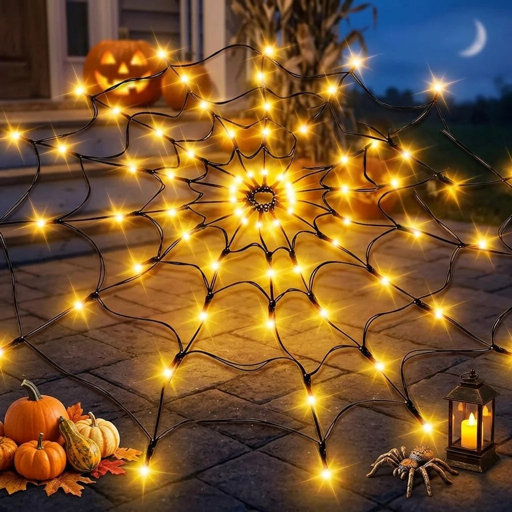 Orange round spider web light in a staged Halloween display