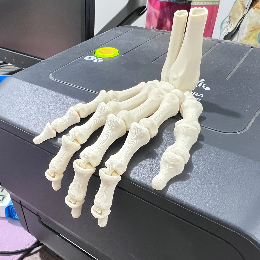 Small skeleton hand ornament resting on a laptop
